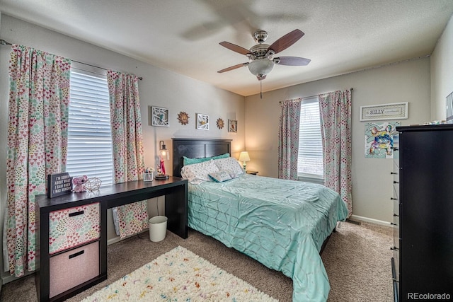 carpeted bedroom featuring ceiling fan and a textured ceiling