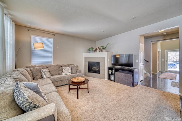 living room with a fireplace, carpet floors, and a textured ceiling