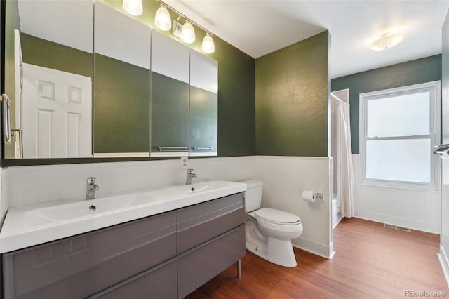 bathroom featuring vanity, wood-type flooring, and toilet