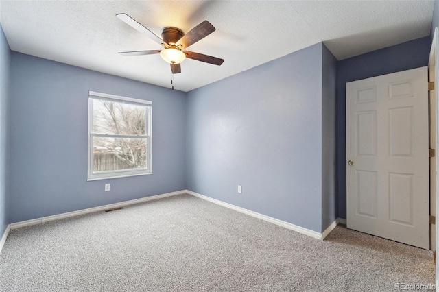 carpeted empty room featuring a textured ceiling and ceiling fan