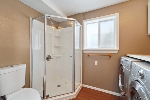 bathroom featuring hardwood / wood-style floors, independent washer and dryer, toilet, and walk in shower