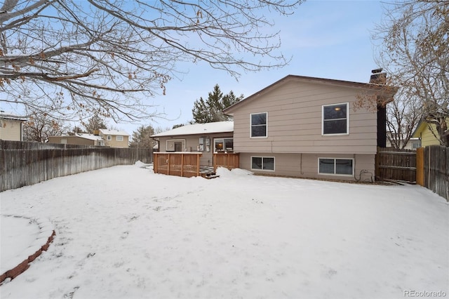 snow covered house with a wooden deck