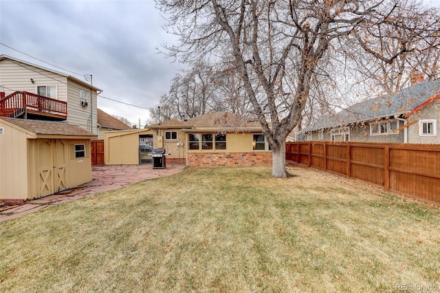 view of yard featuring a storage unit and a patio