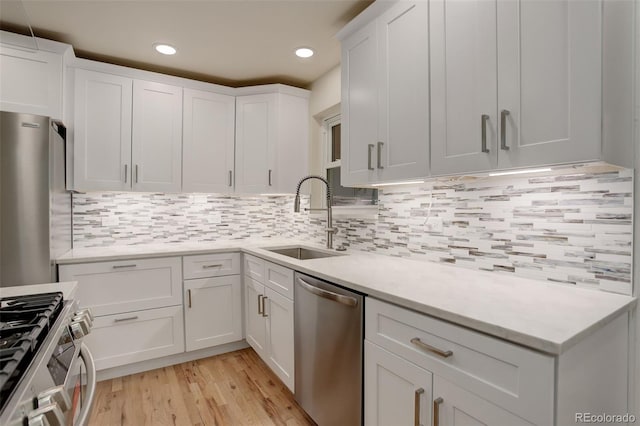 kitchen featuring white cabinetry, appliances with stainless steel finishes, sink, and decorative backsplash