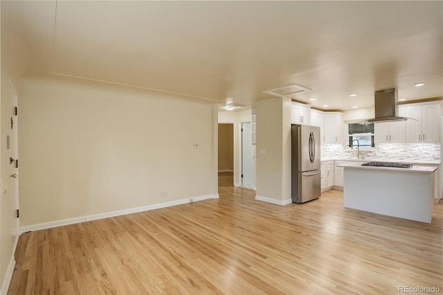 kitchen featuring sink, white cabinetry, backsplash, stainless steel appliances, and island range hood