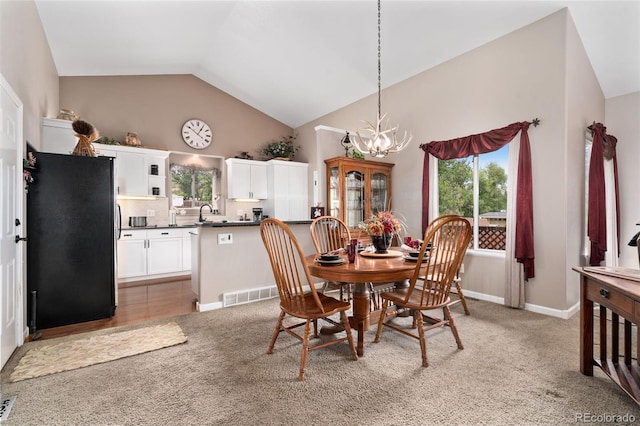 dining room featuring lofted ceiling, visible vents, light carpet, and an inviting chandelier