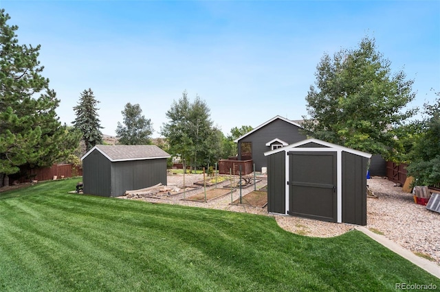 view of yard with an outdoor structure, a vegetable garden, a storage shed, and fence