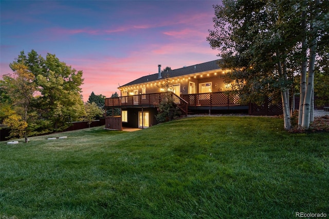 rear view of property with a yard and a wooden deck