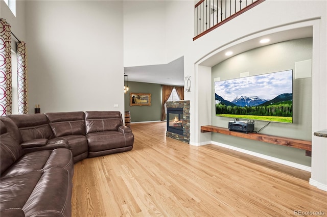 5049 Heatherglen Dr, Highlands Ranch, CO 80130 - living area featuring wood finished floors, a high ceiling, a stone fireplace, baseboards, and recessed lighting
