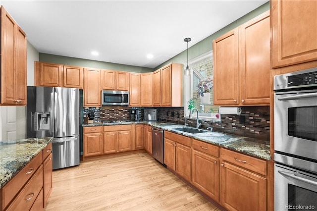 5049 Heatherglen Dr, Highlands Ranch, CO 80130 - kitchen with appliances with stainless steel finishes, a sink, light wood-style floors, decorative backsplash, and recessed lighting