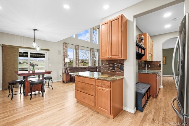 5049 Heatherglen Dr, Highlands Ranch, CO 80130 - kitchen featuring freestanding refrigerator, a sink, light wood-type flooring, tasteful backsplash, and dark stone counters