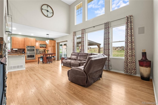 5049 Heatherglen Dr, Highlands Ranch, CO 80130 - living room featuring a high ceiling, light wood-type flooring, and baseboards