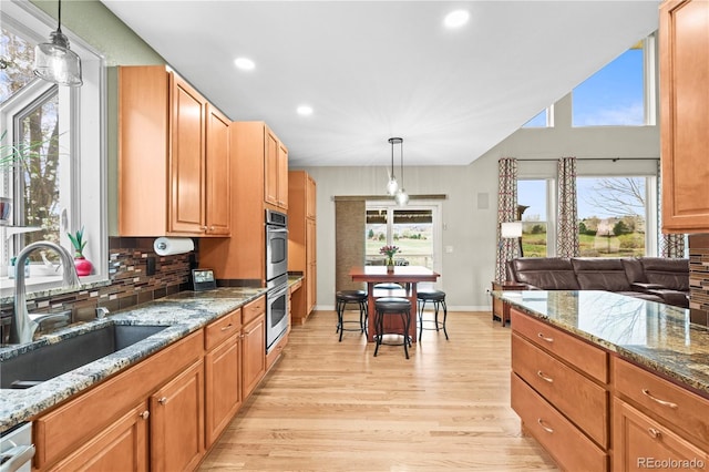 5049 Heatherglen Dr, Highlands Ranch, CO 80130 - kitchen featuring a sink, light wood-style flooring, backsplash, recessed lighting, and stone counters