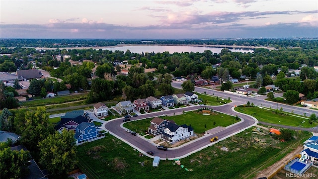 aerial view at dusk featuring a water view