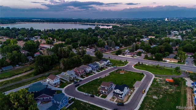 aerial view at dusk featuring a water view