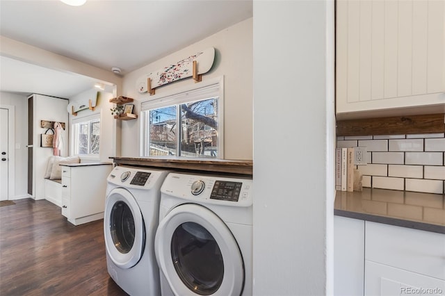 clothes washing area with washer and dryer, dark wood-style flooring, and laundry area