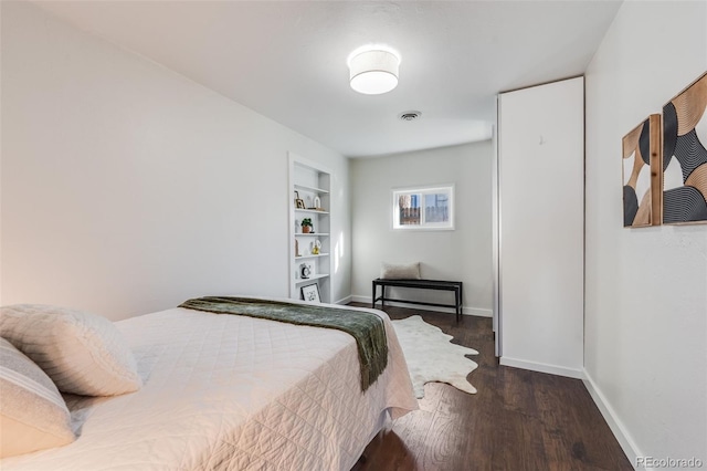 bedroom featuring visible vents, baseboards, and wood finished floors