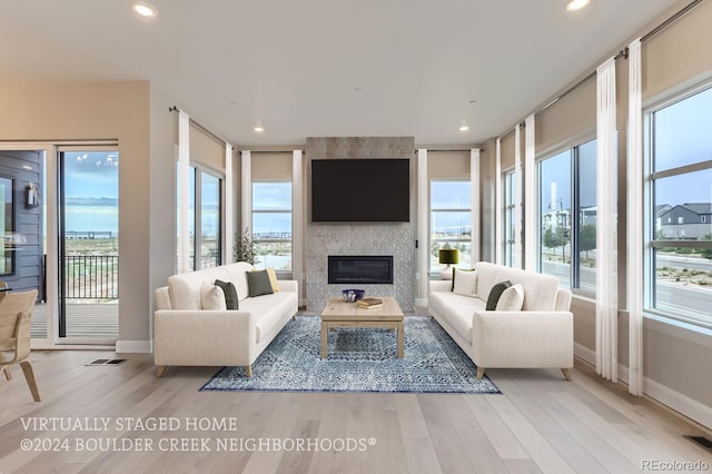 living room featuring light hardwood / wood-style floors and a large fireplace