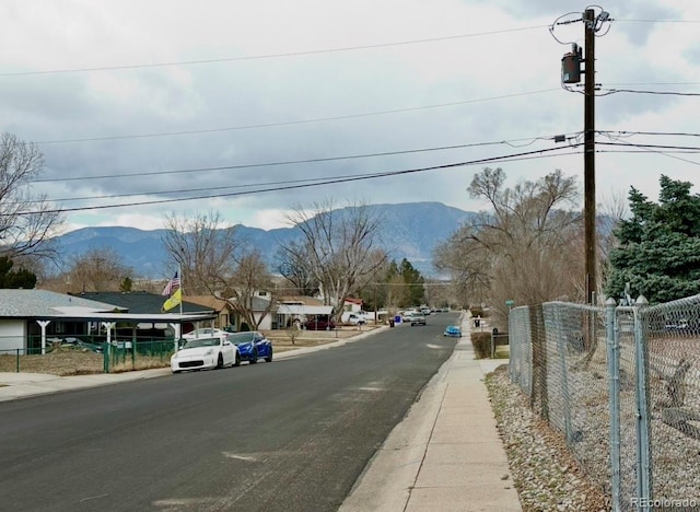 view of road with curbs, a mountain view, and sidewalks