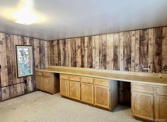 bar featuring lofted ceiling, built in desk, wood walls, and light colored carpet