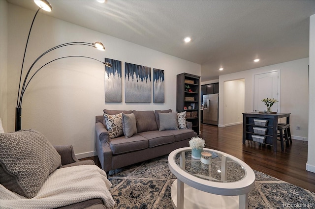 living room featuring dark wood-type flooring, recessed lighting, and baseboards