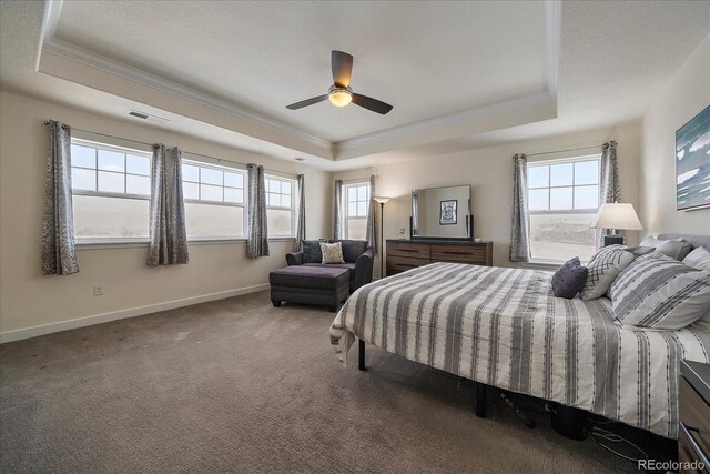 carpeted bedroom with multiple windows, a raised ceiling, and crown molding