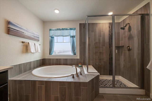 full bathroom featuring a shower stall, vanity, and a bath