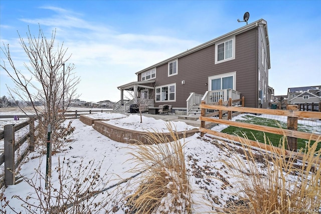 snow covered property with fence and a wooden deck