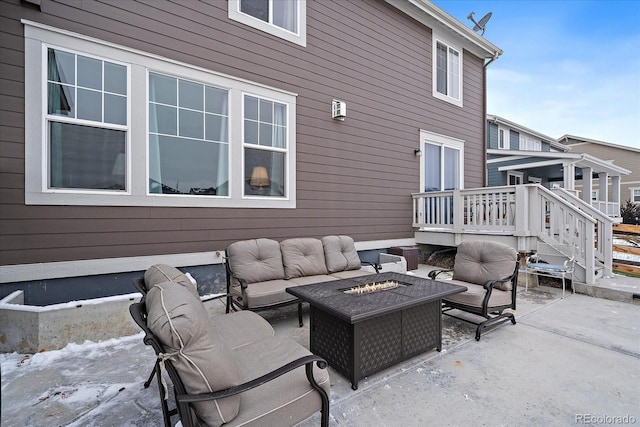view of patio / terrace with a wooden deck and an outdoor living space with a fire pit