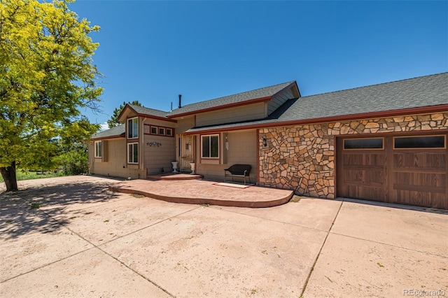 42313 Vista Rdg, Parker, CO 80138 - view of front of house featuring driveway, a garage, a shingled roof, and stone siding