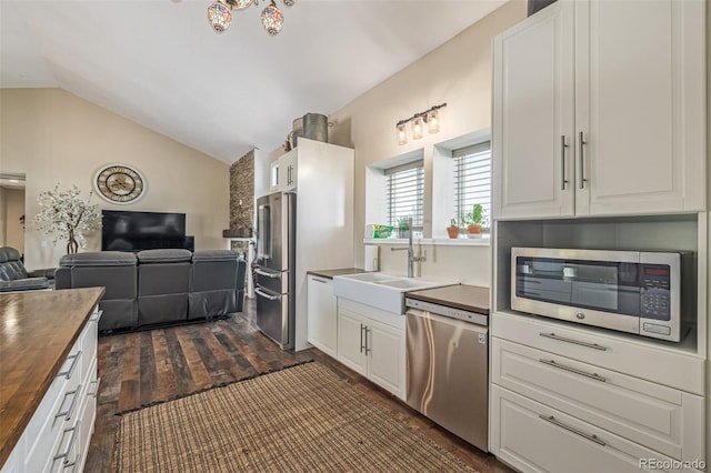42313 Vista Rdg, Parker, CO 80138 - kitchen with butcher block counters, stainless steel appliances, vaulted ceiling, open floor plan, and dark wood-style floors