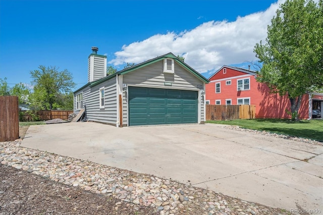 11337 E 1st Ave, Aurora, CO 80010 - view of home's exterior featuring a garage, concrete driveway, and a chimney