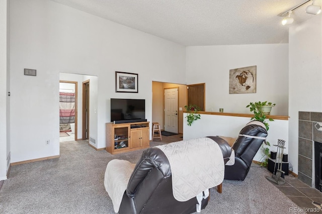 11337 E 1st Ave, Aurora, CO 80010 - carpeted living area featuring a textured ceiling, high vaulted ceiling, a fireplace, and baseboards