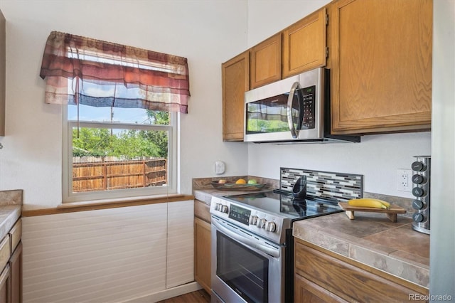 11337 E 1st Ave, Aurora, CO 80010 - kitchen with appliances with stainless steel finishes and brown cabinetry