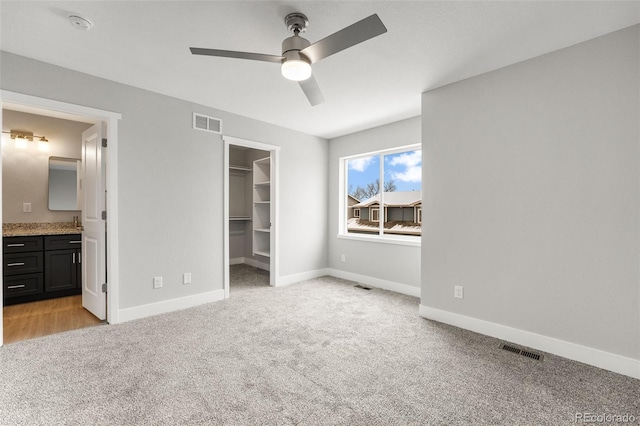 420 Molly Ln, Fort Morgan, CO 80701 - unfurnished bedroom with a spacious closet, visible vents, and light colored carpet