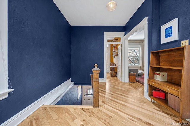 interior space with baseboards and wood finished floors