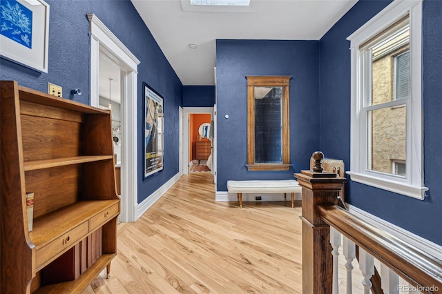 corridor with wood finished floors and baseboards