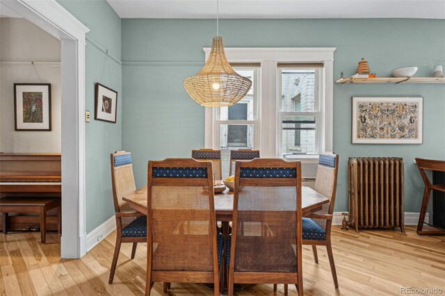 dining space with light wood finished floors, radiator heating unit, and baseboards