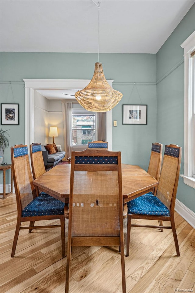 dining area featuring light wood-style flooring and baseboards