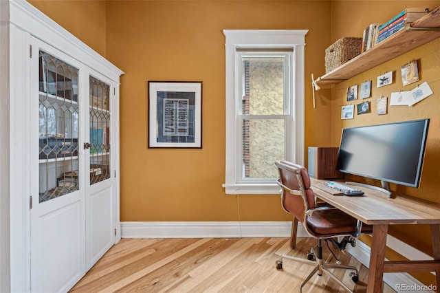 office featuring wood finished floors, a wealth of natural light, and baseboards