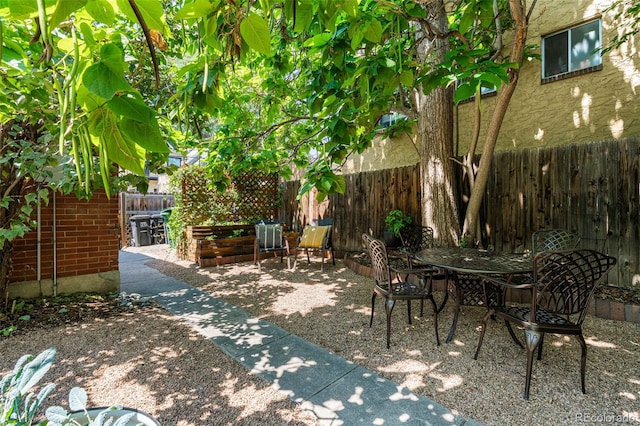 view of patio featuring outdoor dining area and fence