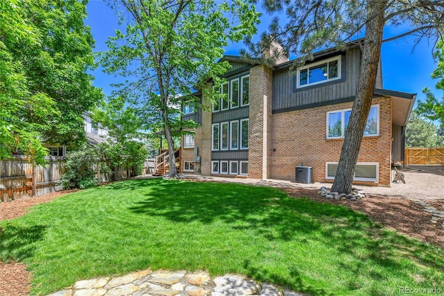 11209 Quivas Loop, Westminster, CO 80234 - back of property featuring brick siding, stairway, and central AC