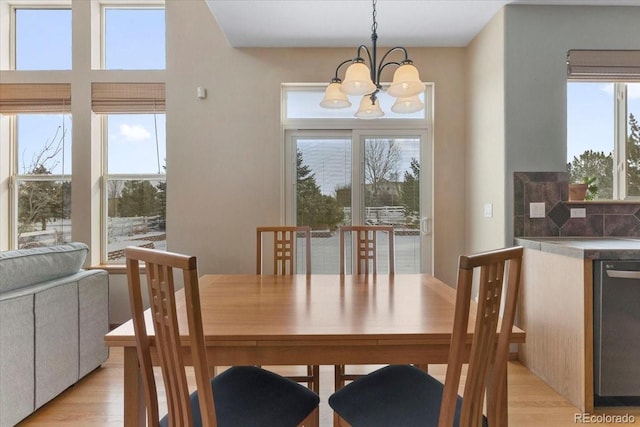 dining space featuring light hardwood / wood-style floors and a notable chandelier