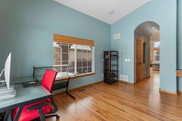 home office with light hardwood / wood-style flooring and lofted ceiling