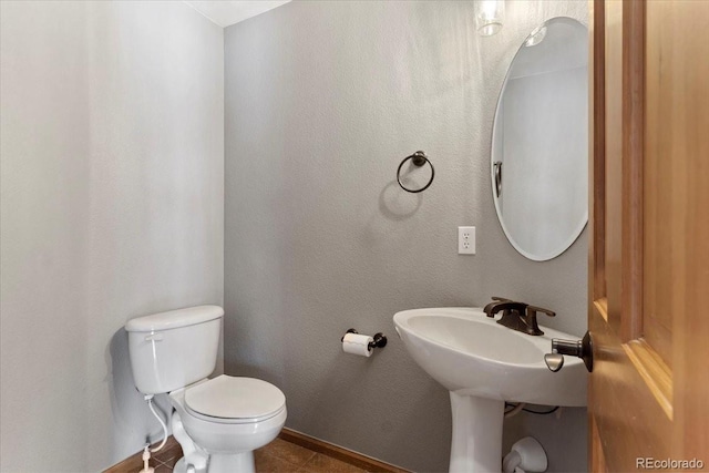 bathroom with toilet and tile patterned floors