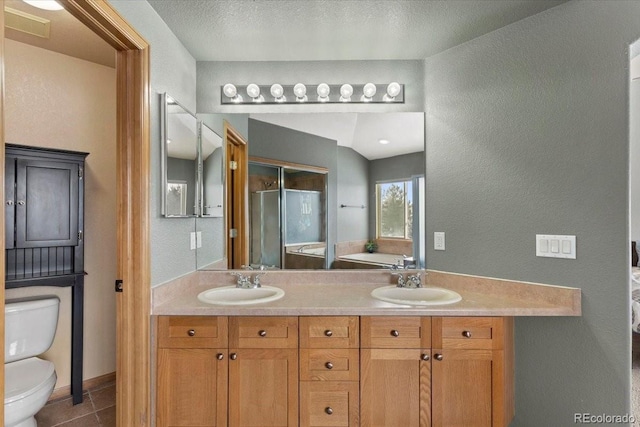 bathroom featuring a textured ceiling, toilet, vanity, and tile patterned flooring