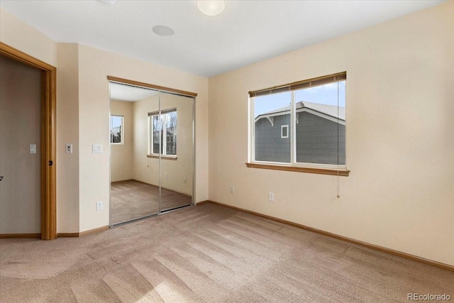 unfurnished bedroom featuring a closet and light carpet