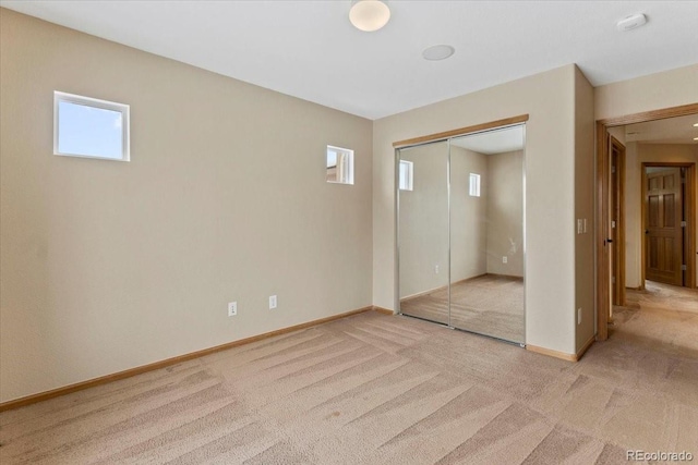 unfurnished bedroom featuring a closet, light carpet, and multiple windows