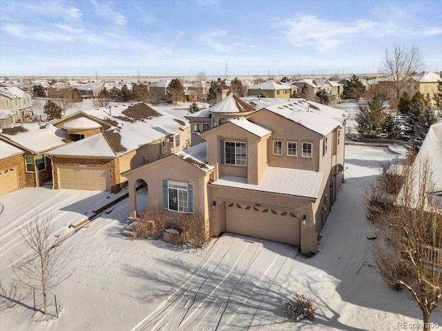 view of front of house with decorative driveway, a garage, a residential view, and stucco siding