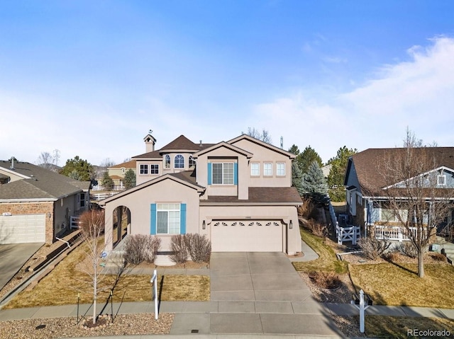 traditional-style home featuring stucco siding, driveway, and an attached garage